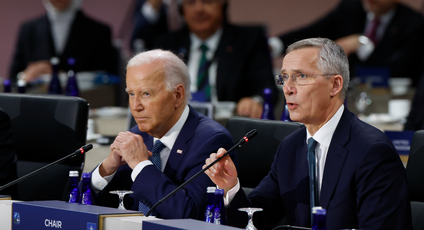 Biden and Stoltenberg sit in front of mikes at the NATO summit