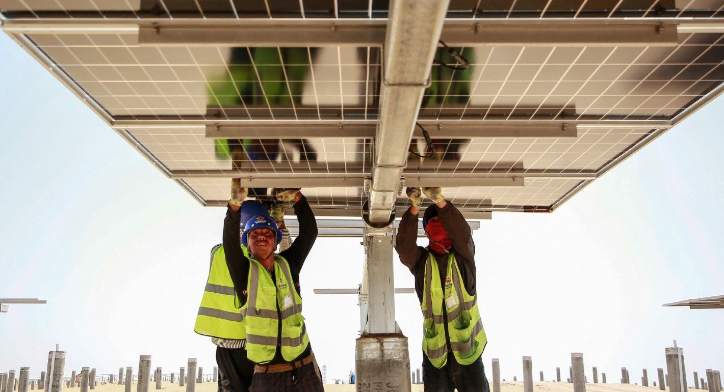 The photo taken on May 9, 2024 shows workers installing photovoltaic panels at the Ningxia Tengger Desert New Energy Base in Zhongwei, in China's northern Ningxia region. 