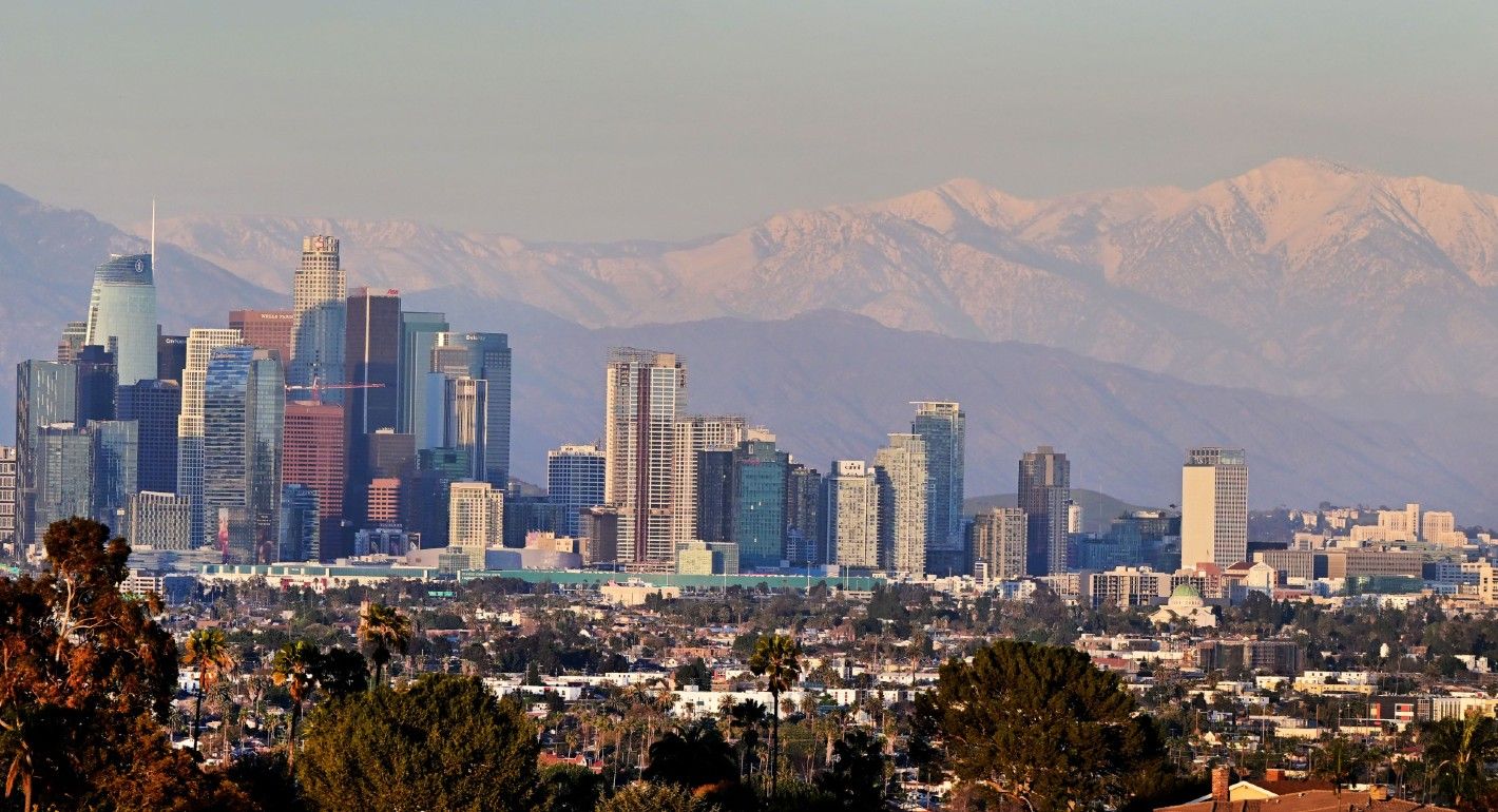 Snow-capped mountains are seen in the distance behind the downtown skyline on March 2, 2023 in Los Angeles, California 