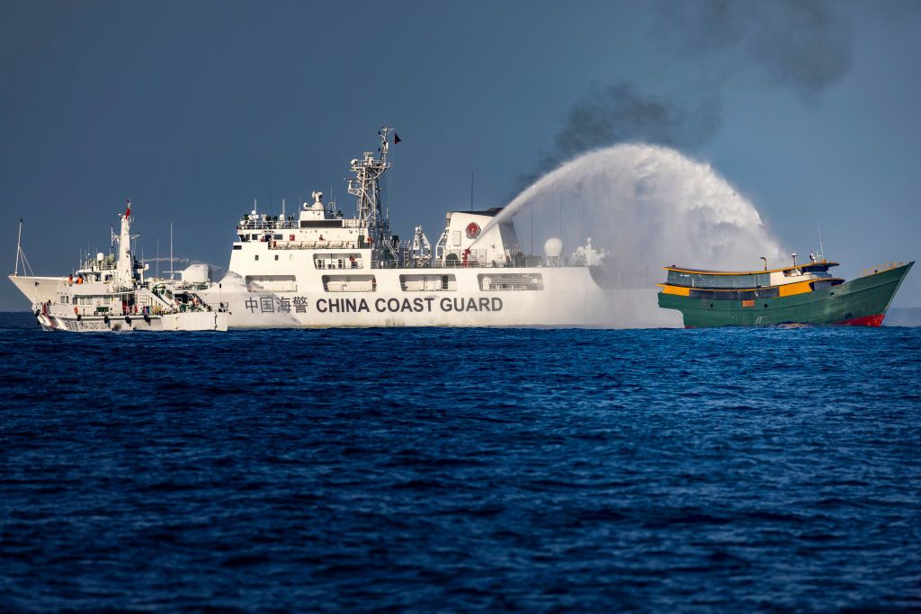 A Chinese Coast Guard ship fires a water cannon at a Philippine Navy chartered vessel conducting a routine resupply mission to troops stationed at Second Thomas Shoal in the South China Sea, on March 5, 2025. Source: Photo by Ezra Acayan/Getty Images 