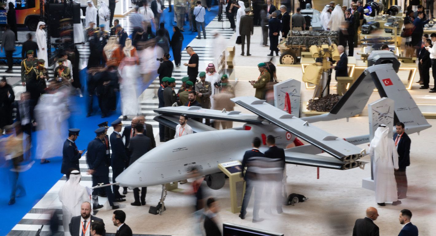 People walk by a drone in a conference center