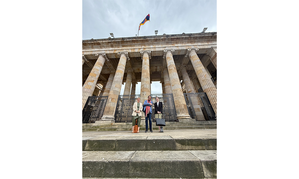 the authors posing on the steps of a building with columns