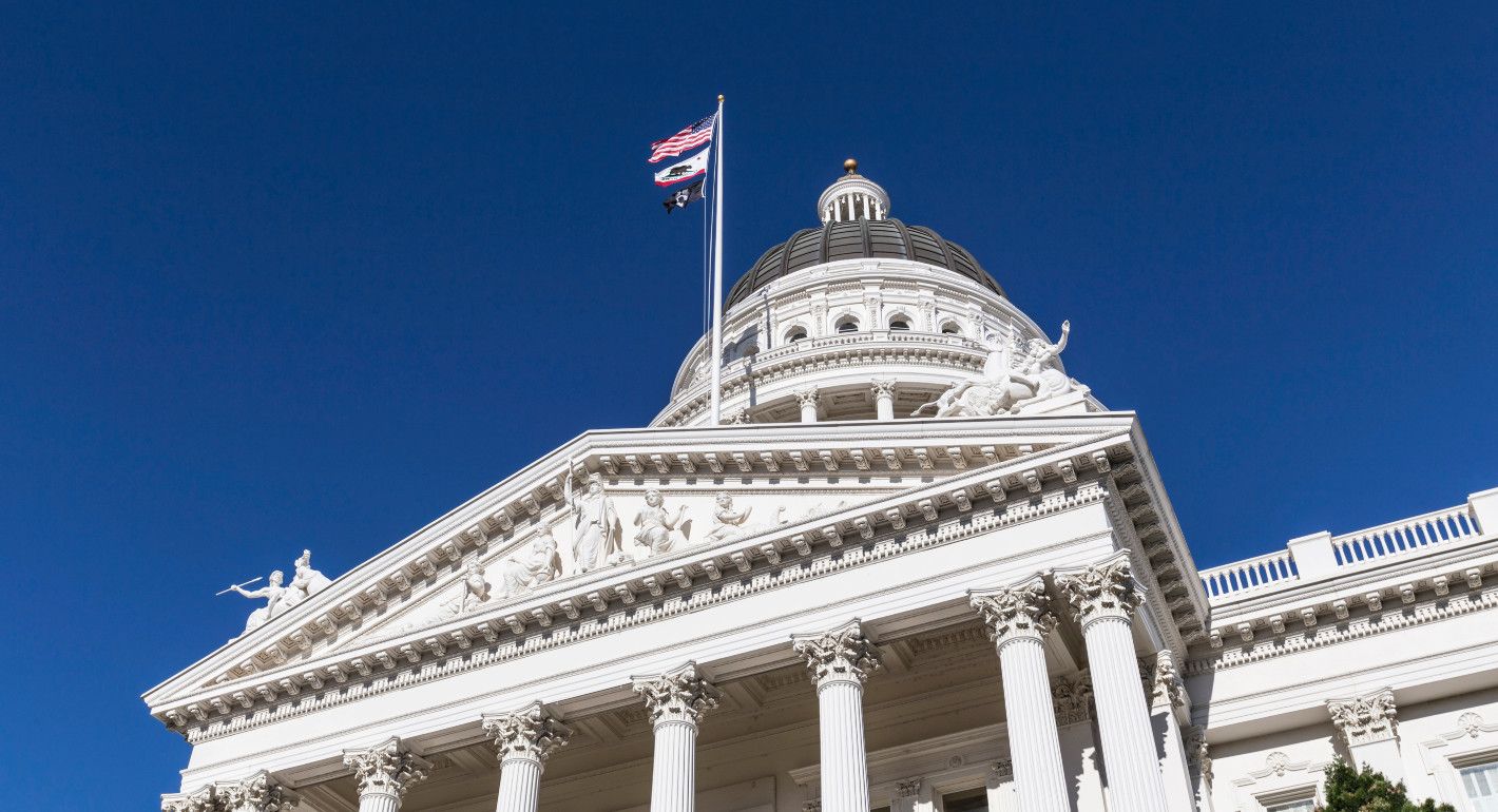 California capitol building dome with US and state flags