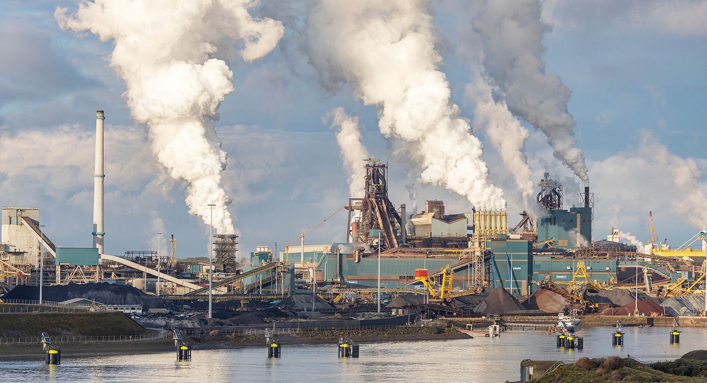Steel plant at IJmuiden on the north coast of the Netherlands with clouds of Cardon Dioxide coming out of towers from the combustion of natural gas.