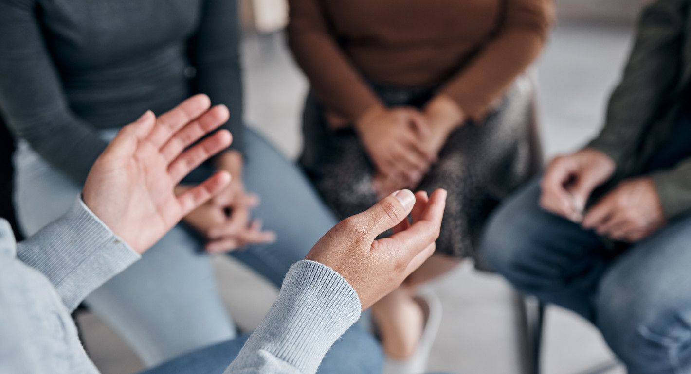 Photo of a people sitting in a circle talking.