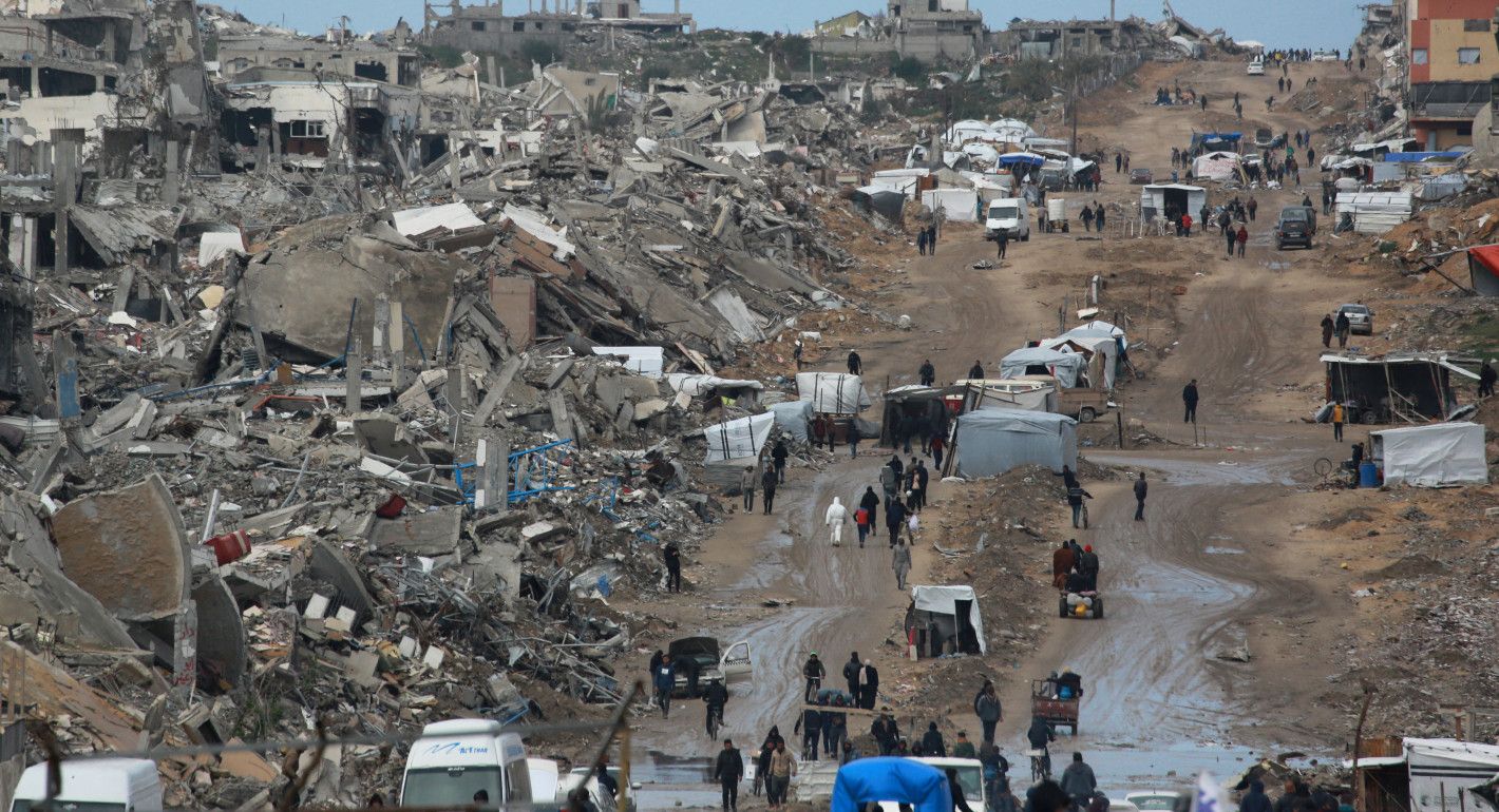 People walking amid destroyed buildings