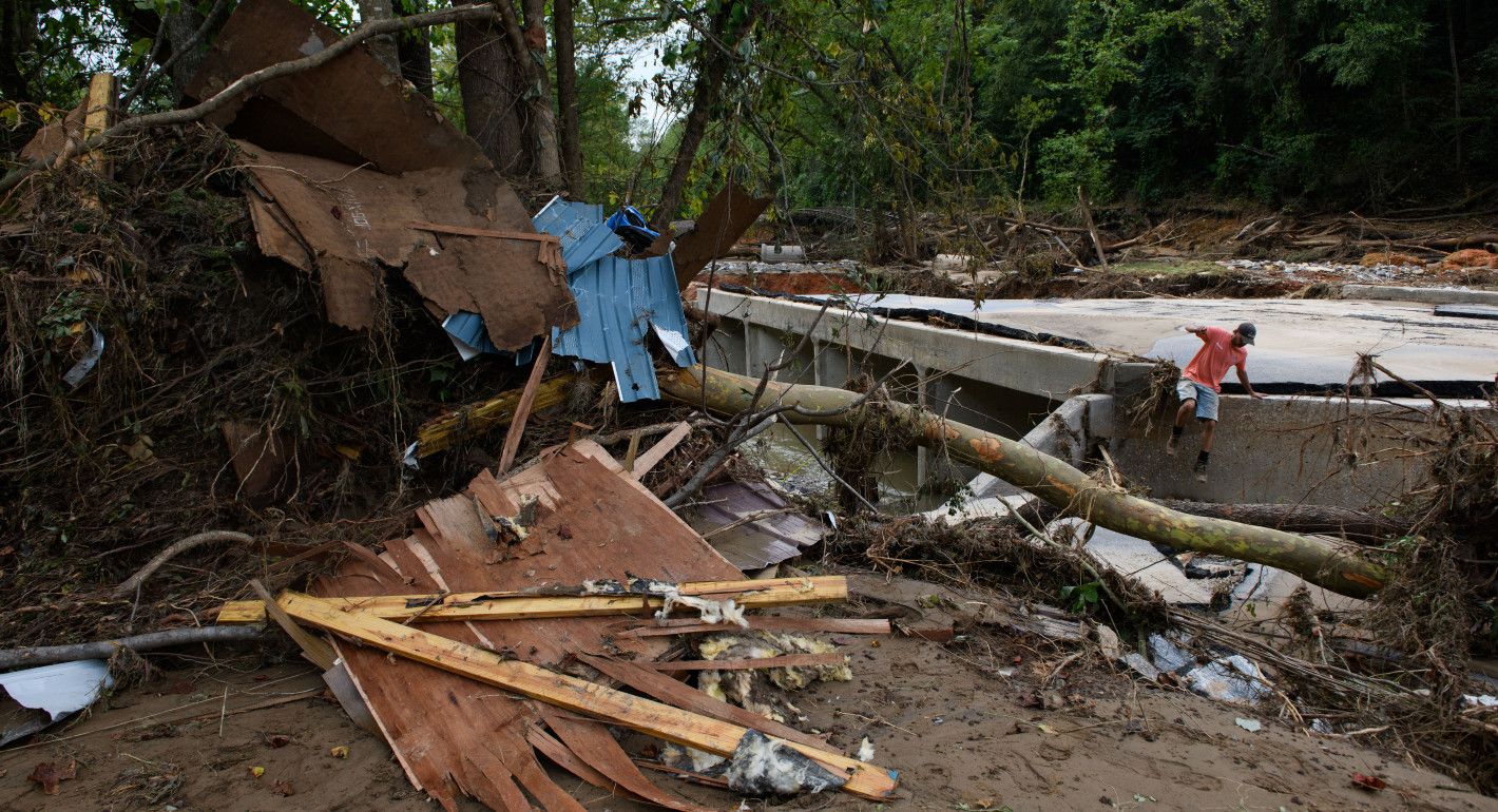 Man climbing down from a broken road near a pile of debris