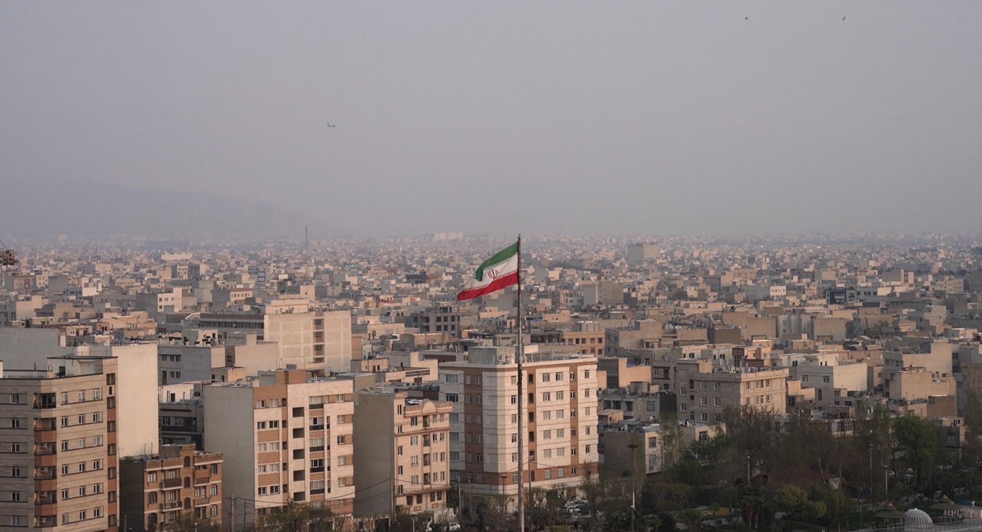 The city of Tehran with the Iranian flag waving in the middle