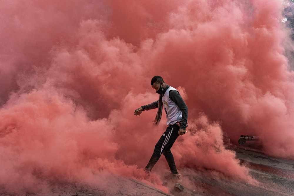 Protester surrounded by pink smoke