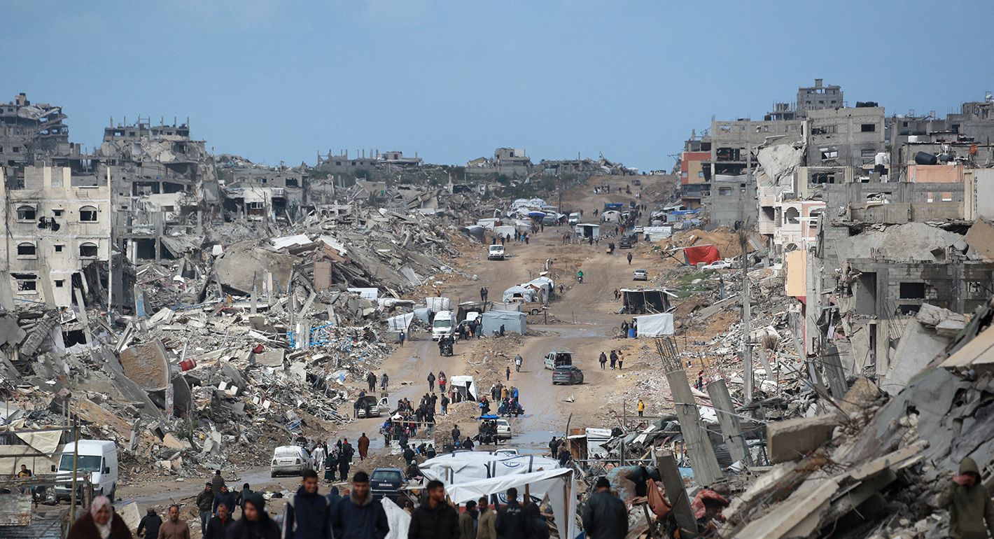 Displaced Palestinians walk through a muddy road amid the destruction in Jabalia in the northern Gaza Strip on February 6, 2025, during a truce in the war between Israel and Hamas. 