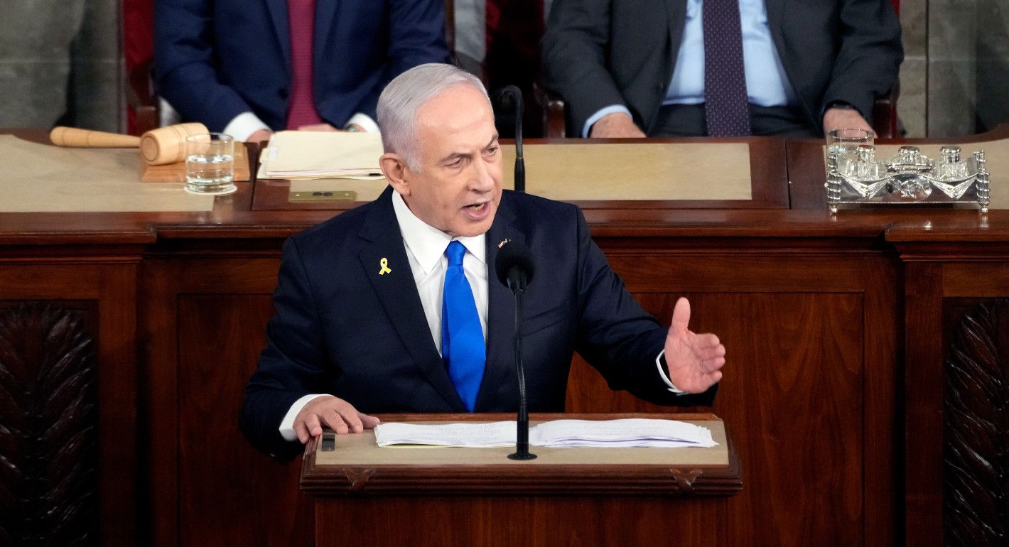 Netanyahu standing at a dais gesturing while speaking