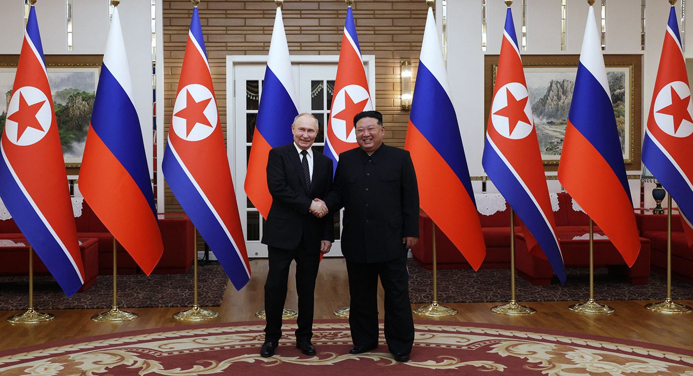 In this pool photograph distributed by the Russian state agency Sputnik, Russia's President Vladimir Putin (L) shakes hands with North Korea's leader Kim Jong Un during a meeting in Pyongyang on June 19, 2024