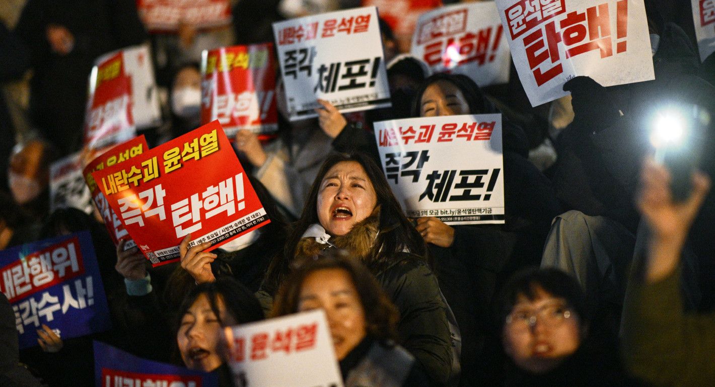 people holding signs and yelling