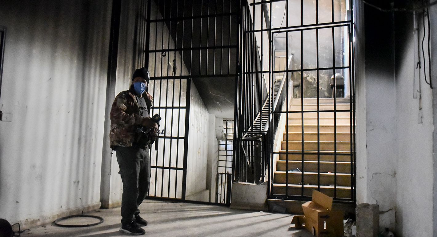 A person stands near the main entrance of the Palestine Branch Prison in Damascus, Syria, on December 18, 2024