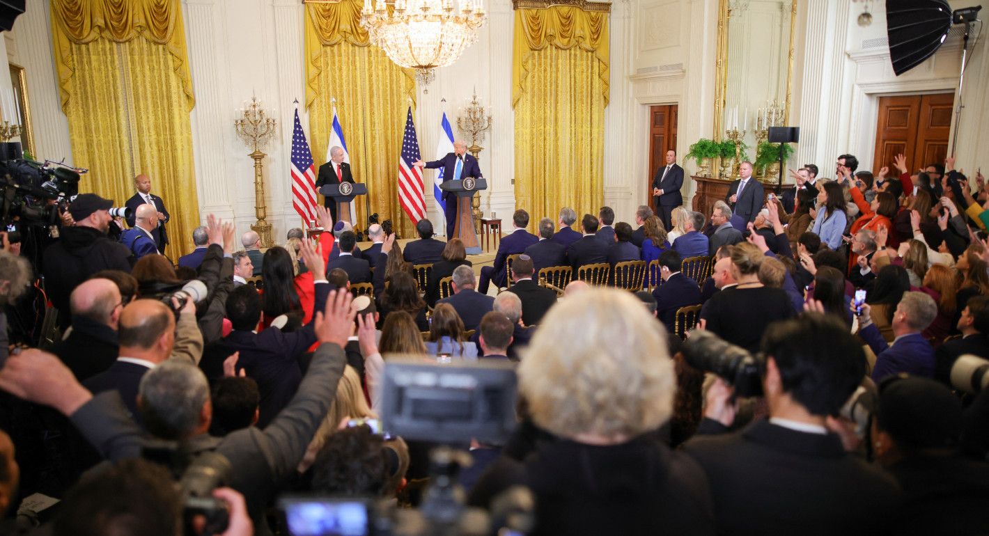 Wide shot of a crowded room with an audience facing Netanyahu and Trump, who are speaking