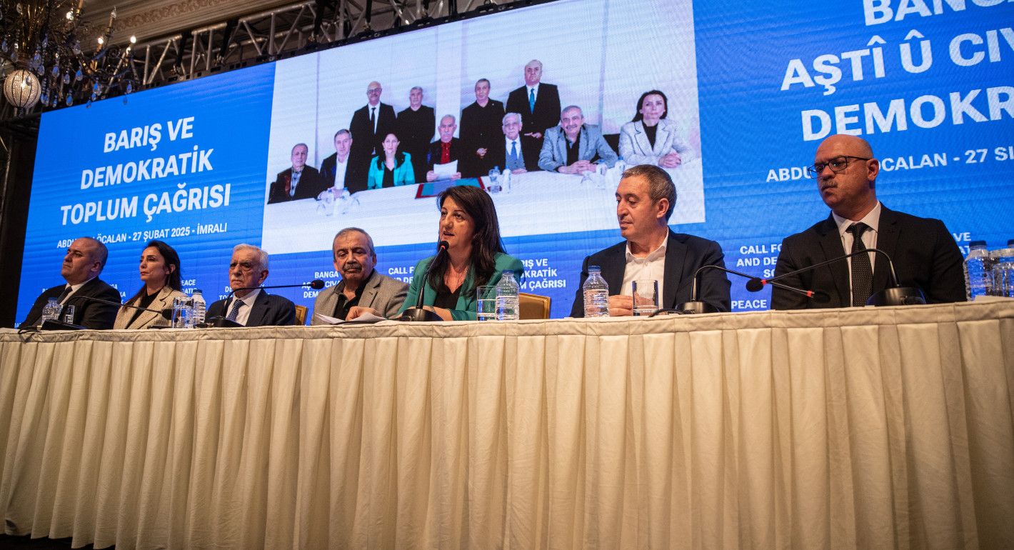 people sitting at a table with mics