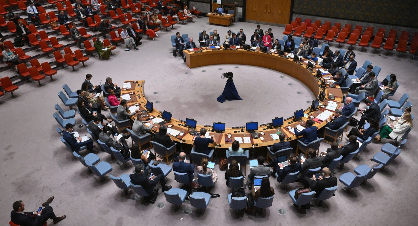 An overhead view of the UN Security Council meeting room, with members and staff seated in a semicircle