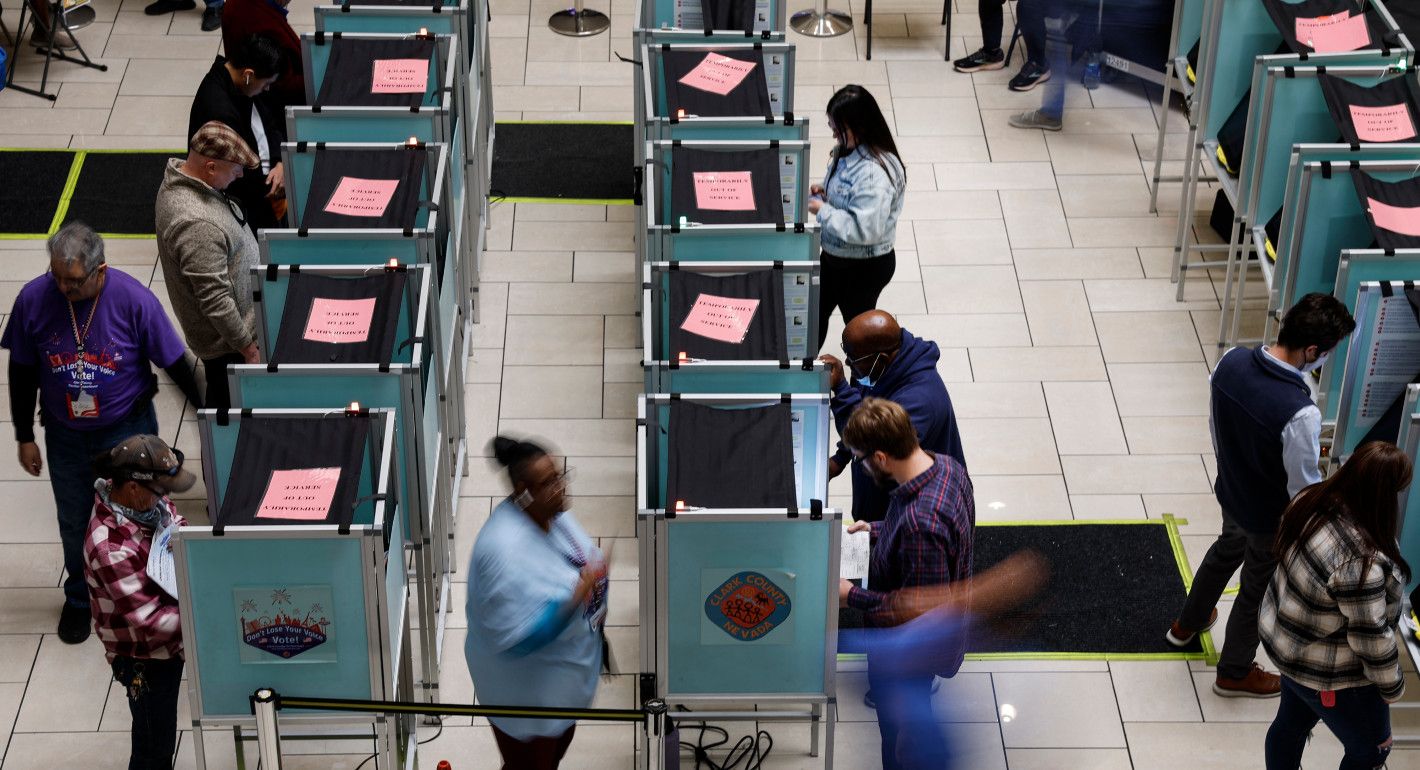 overhead shot of people casting ballots in voting booths