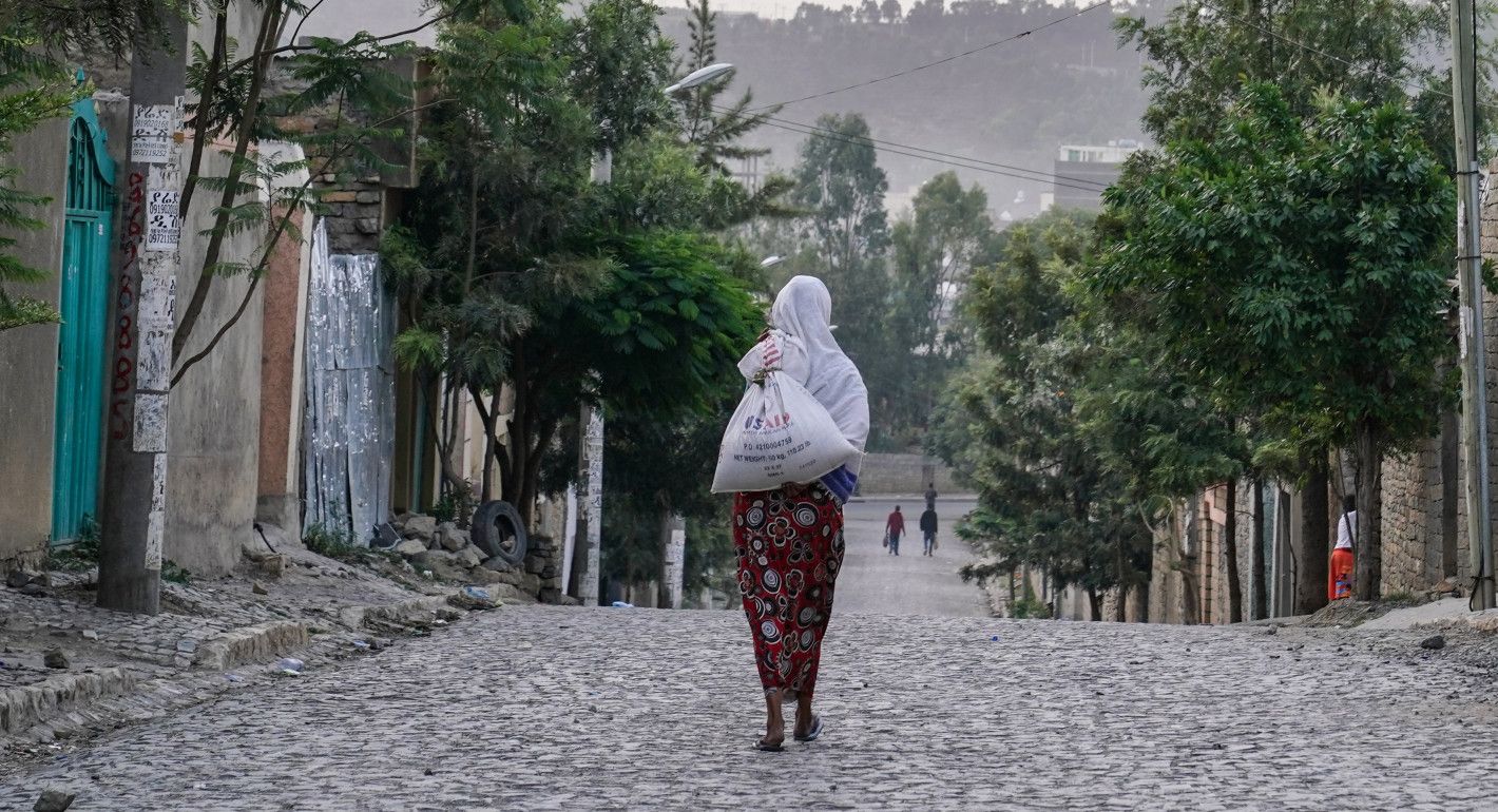 Woman walks away from the camera with a USAID bag