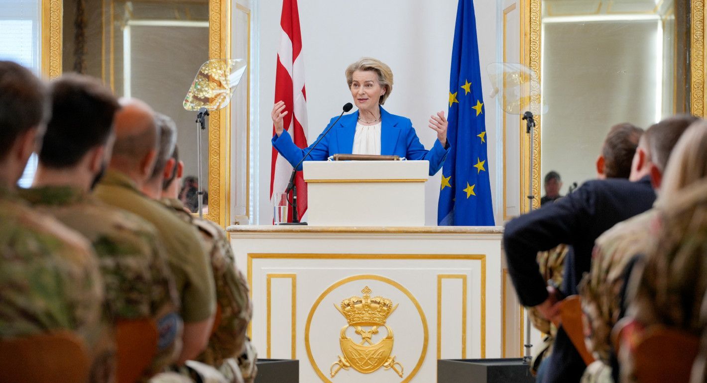 Von der Leyen speaking at a lectern to seated military members